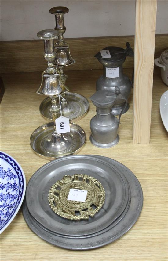A pair silver plated brass tavern candlesticks, three pewter plates, two measures and